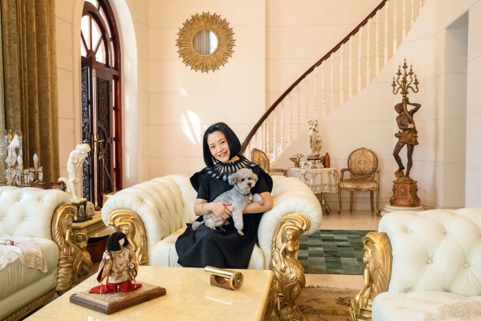 The designer at home in Beijing with her poodle, Nuomi (“Sticky Rice”)