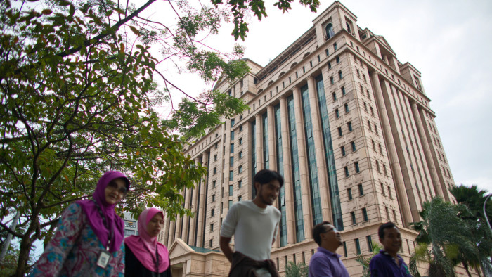 People walk past the headquarters of the Bursa Malaysia