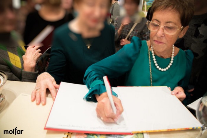 Violetta Prigozhin pictured in 2017 signing a book surrounded by people