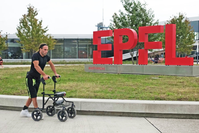 Michel Roccati uses a walker to assist his walking outside the EPFL building 