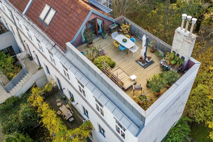 roof terrace with plants, table and chairs and chimney