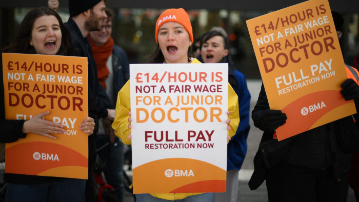 People holding placards calling for better pay on a picket line outside the Royal London Hospital in east London