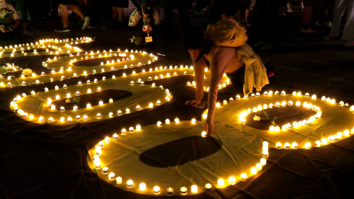 A woman arranges a candle at a candlelight vigil in Taipei 