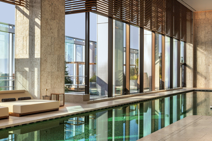 The hotel’s pool, overlooked by floor-to-ceiling windows, with a double daybed to its side