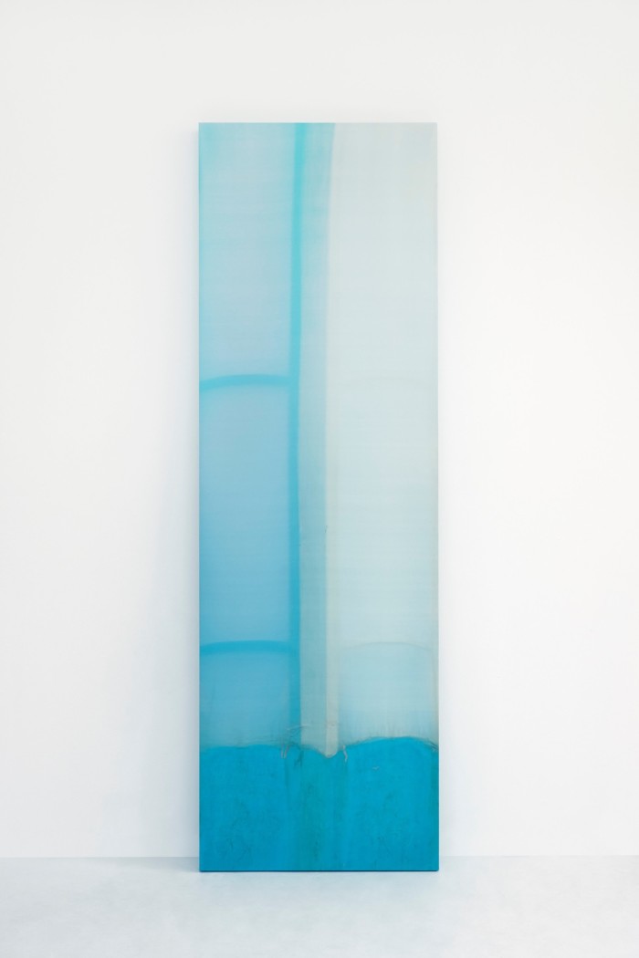 A tall rectangular sculpture which starts medium blue at the bottom and fades to white at the top