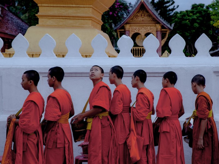 The daily alms-giving ceremony at sunrise outside the Wat Sen temple in Luang Prabang
