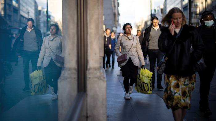 People carry shopping bags on Oxford Street in central London on