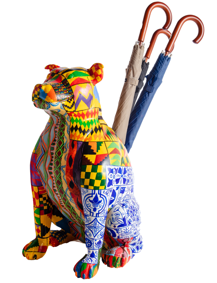 A colourful mixture of geometric shapes covers an ornamental pitbull which has three umbrellas sticking out of its back 