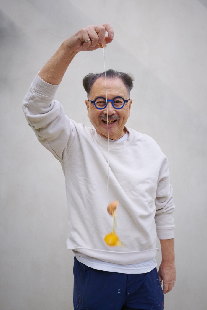 Chow wearing his new children’s glasses from Boots and cracking an egg – he uses them in his paintings
