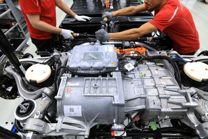 Workers assemble a Taycan engine at a Porsche plant in Stuttgart
