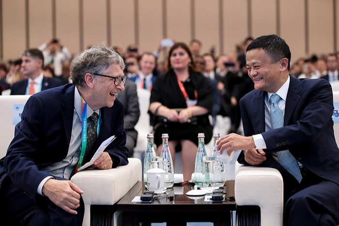 Ma sits at a table with Microsoft’s Bill Gates at the China International Import Expo in Shanghai in 2018