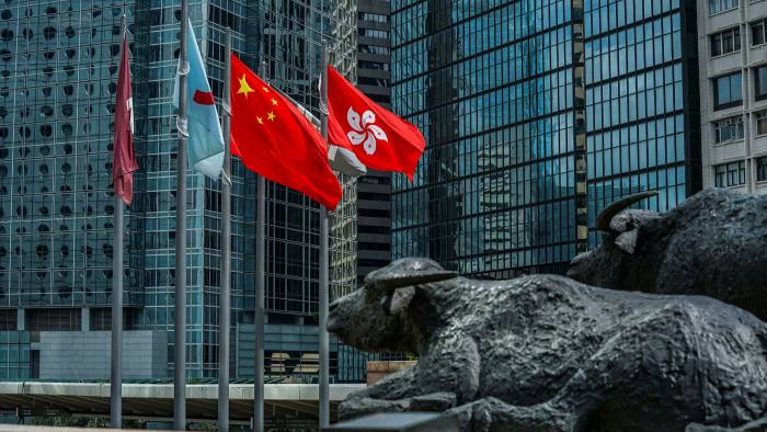 The flag of the Hong Kong Special Administrative Region, right, flies alongside the flag of China outside the Exchange Square complex in Hong Kong
