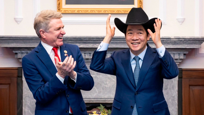 Lai Ching-te putting on a cowboy hat as Michael McCaul claps his hands