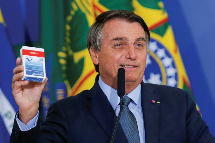 President Jair Bolsonaro holds a pack of chloroquine at the inauguration of a health minister