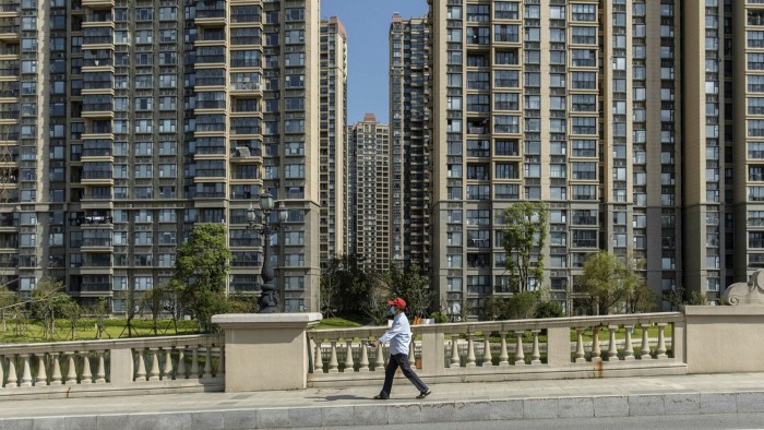 A resident walks past Evergrande apartment buildings in China