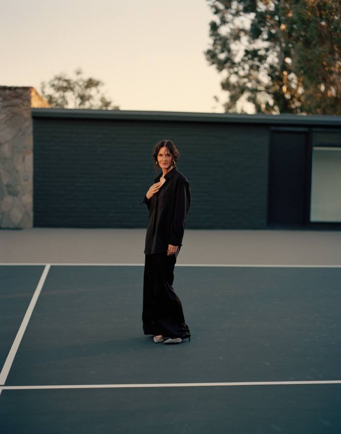 Cox on her tennis court. She wears Another Tomorrow wool shirt, £465, and wool-mix trousers, £583. Hannah Martin Jewellery gold rings, POA. Hair, Debra Ferullo. Make-up, Ericka Verrett