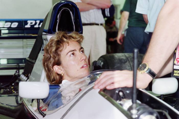 racing driver Giovanna Amati in the race car talking to a mechanic