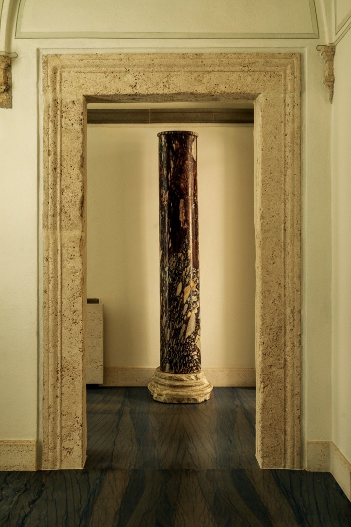 A travertine doorway from the 15th-century building frames a second-century breccia column