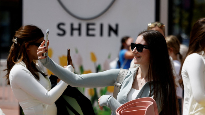 A woman takes a selfie at a Shein pop-up store
