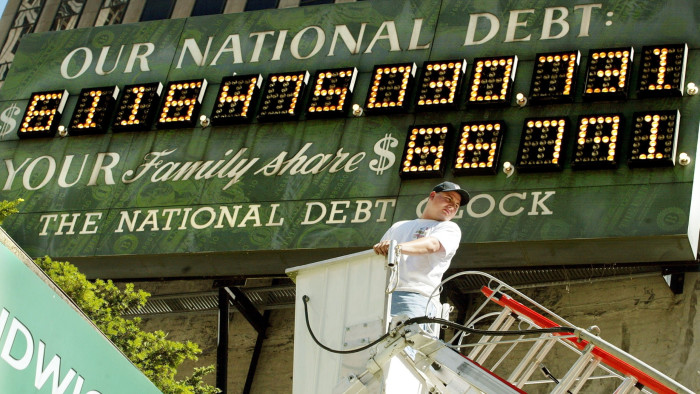 A worker mans a crane beneath the National Debt Clock after it was restarted July 11, 2002 in New York City.