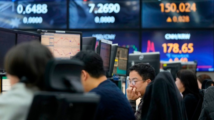 A currency trader watches monitors at the foreign exchange dealing room of KEB Hana Bank headquarters in Seoul