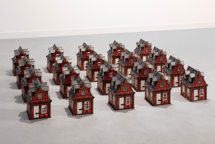 25 small toy houses in a grid of 5 by 5. They look like traditional German houses