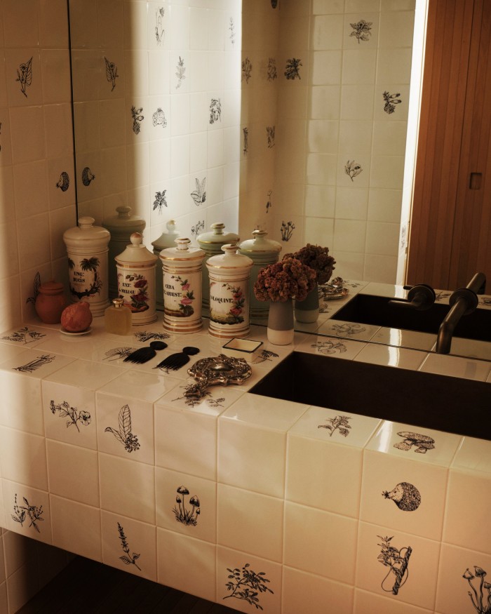 The guest bathroom, with tiles made by Brazilian artist Adriana Varejão and vintage Limoges apothecary jars