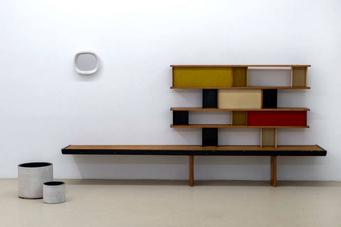 A low set of wooden shelves with colour blocks on each level