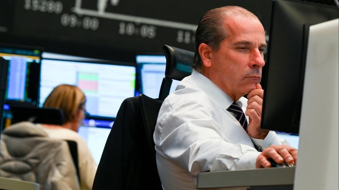 A trader looks at his monitors in the trading room of the Frankfurt stock exchange