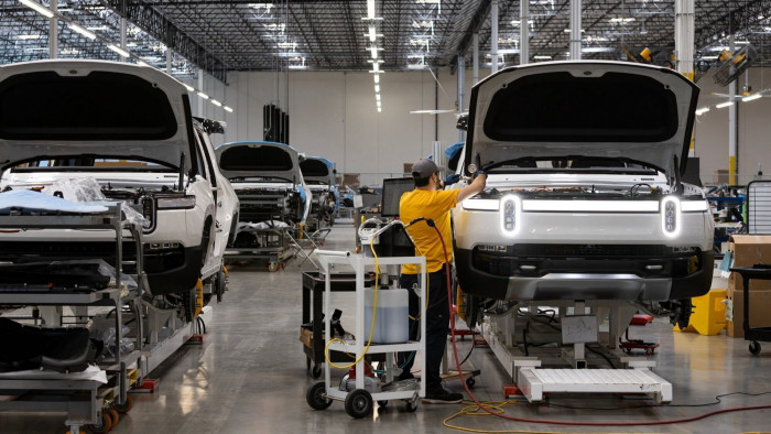 An employee works on a Rivian R1S electric vehicle on the company’s pilot production line in Irvine, California