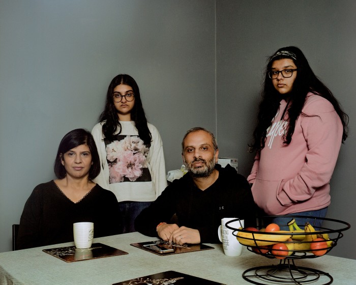 Devi and Manish Solanki (seated), with their daughters at home in East Ham. When Covid hit, Devi lost her sense of taste and smell; Manish ended up in ICU