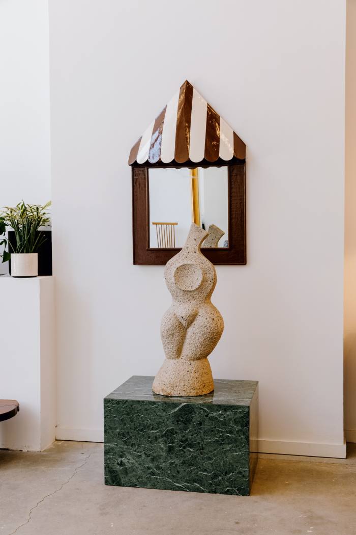 Hand-painted 19th-century awning stripe mirror, $2,890. Midcentury solid granite bust sculpture, $3,500, on top of a marble plinth, $3,650