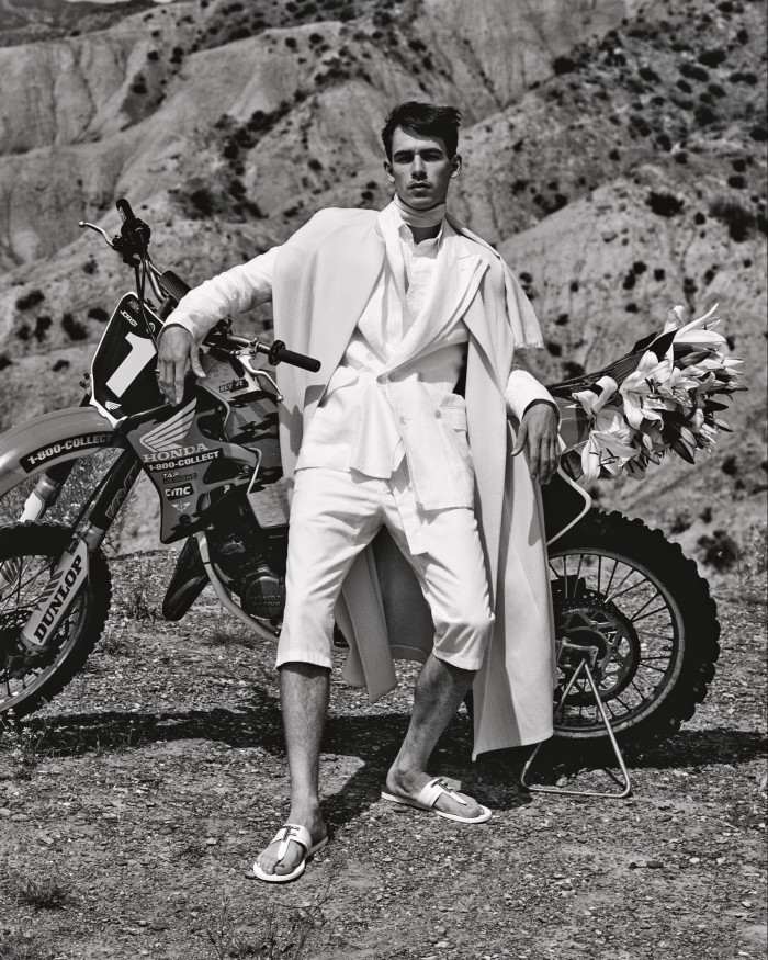Kappe by Federica Bonifaci wool double crepe cape, £850. Dolce & Gabbana linen jacket, £2,050, and cotton drill trousers, £465. Ralph Lauren Purple Label poplin tuxedo shirt, £540. Tom Ford leather and brass Brighton sandals, £690. Vintage silk scarf, stylist’s own. Ring, model’s own