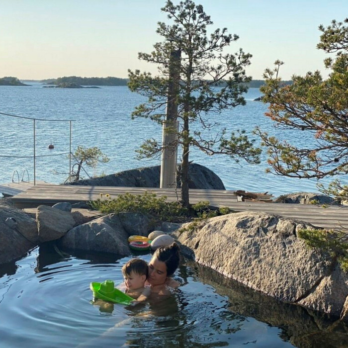 Woman and small boy bathing in rock pool
