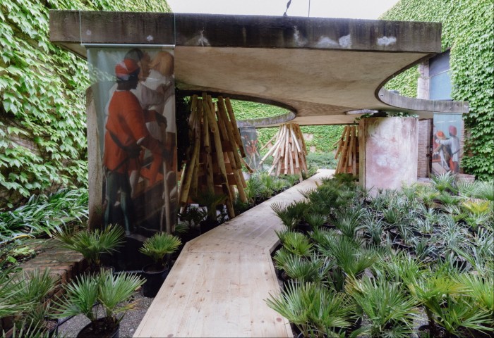 Large mural-like art works installed in a garden next to a winding path