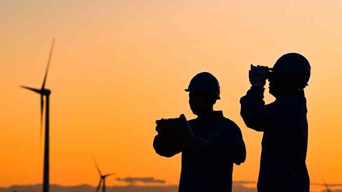 Workers inspect wind turbines
