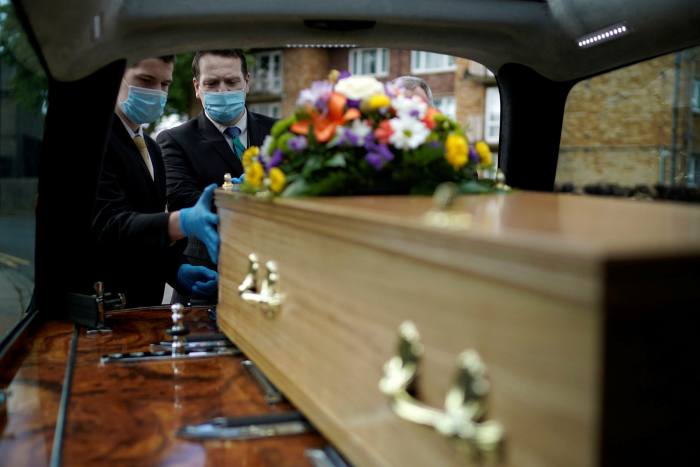 Guardian Funerals staff transport the casket of Covid-19 victim Dennis Clapham, 62, to Nab Wood Crematorium on Tuesday in Shipley, West Yorkshire