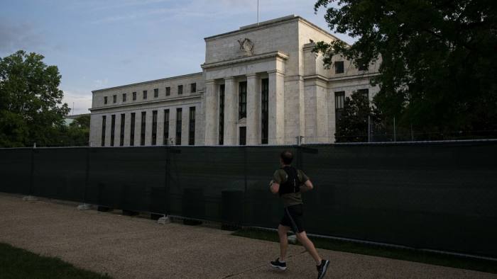 A person walks in front of the Federal Reserve building