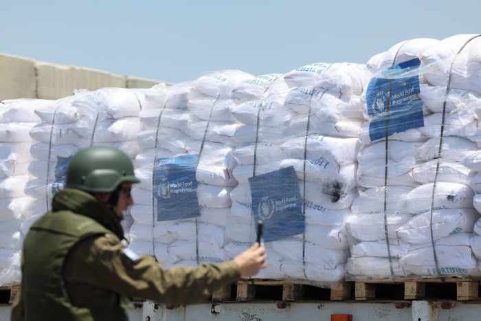 An Israeli soldier checks the cargo of an aid truck at the Kerem Shalom border crossing