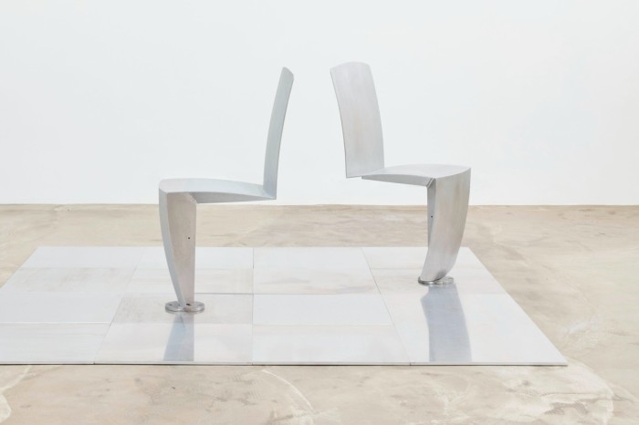 Two silver metal chairs with only legs at the front