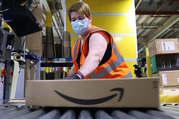 An employee prepares a package for shipment at the Amazon logistics centre in Suelzetal near Magdeburg, eastern Germany