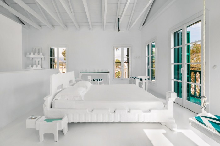 The mezzanine room contains a bed, sofa, mirror and a shelf in a white, green and pink colour combination