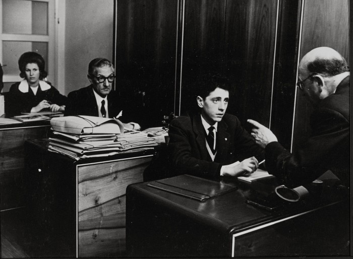 A scene from ‘Il Posto’ of a row of desks in an office, and an older boss haranguing a young male employee