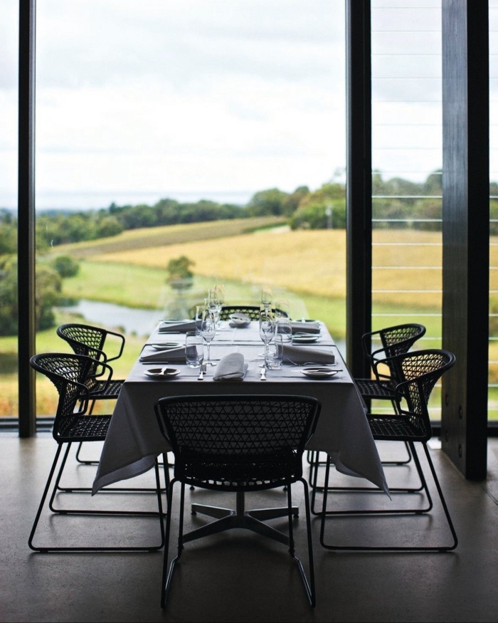 A set table in the estate’s dining room, with views of hills and the sea