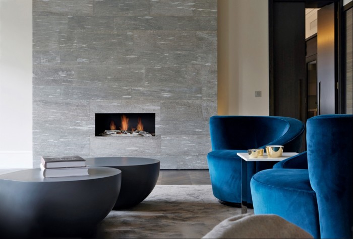 A contemporary fireplace by Tollgard Design is the focal point of the living space in this Chelsea home