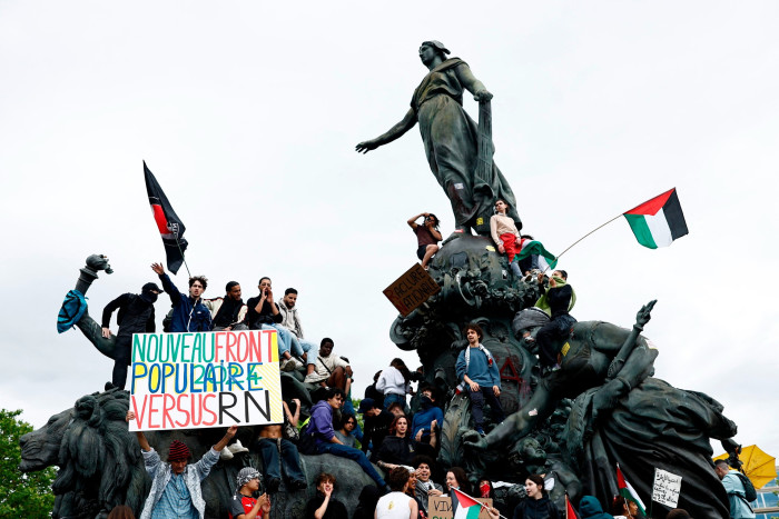 Protesters against the far-right climb on the Triumph of the Republic statue in Paris
