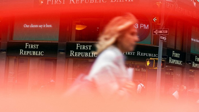 A woman walks near a First Republic Bank branch in New York, US