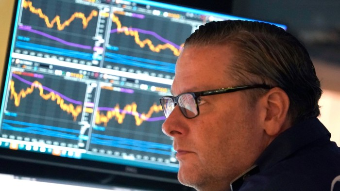 A trader on the floor of the New York Stock Exchange near a monitor