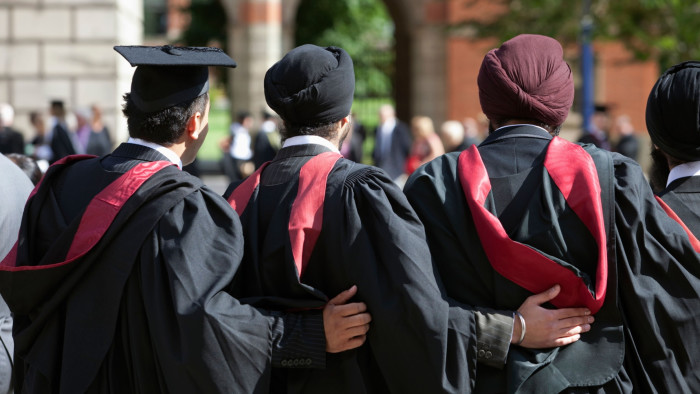 Three students at graduation ceremonies at the University of Birmingham