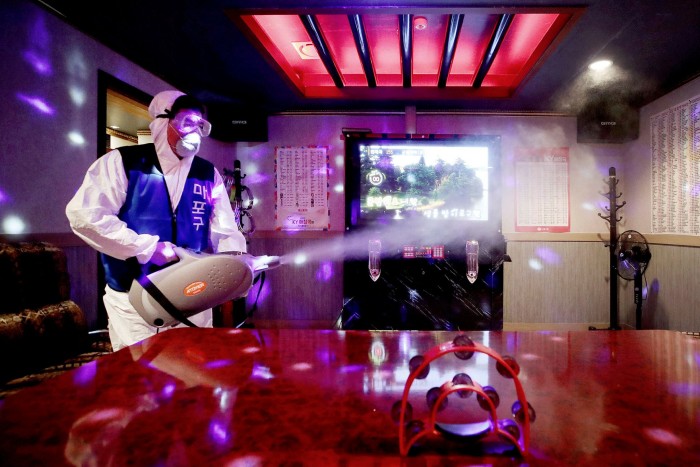 A worker disinfects a Karaoke room in Seoul. Anyone entering one of about 80,000 entertainment venues across the country has to register via a QR code, making it easier for officials to trace Covid-19 outbreaks
